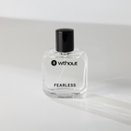 Clear perfume bottle labeled 'without fearless' on a light gray background