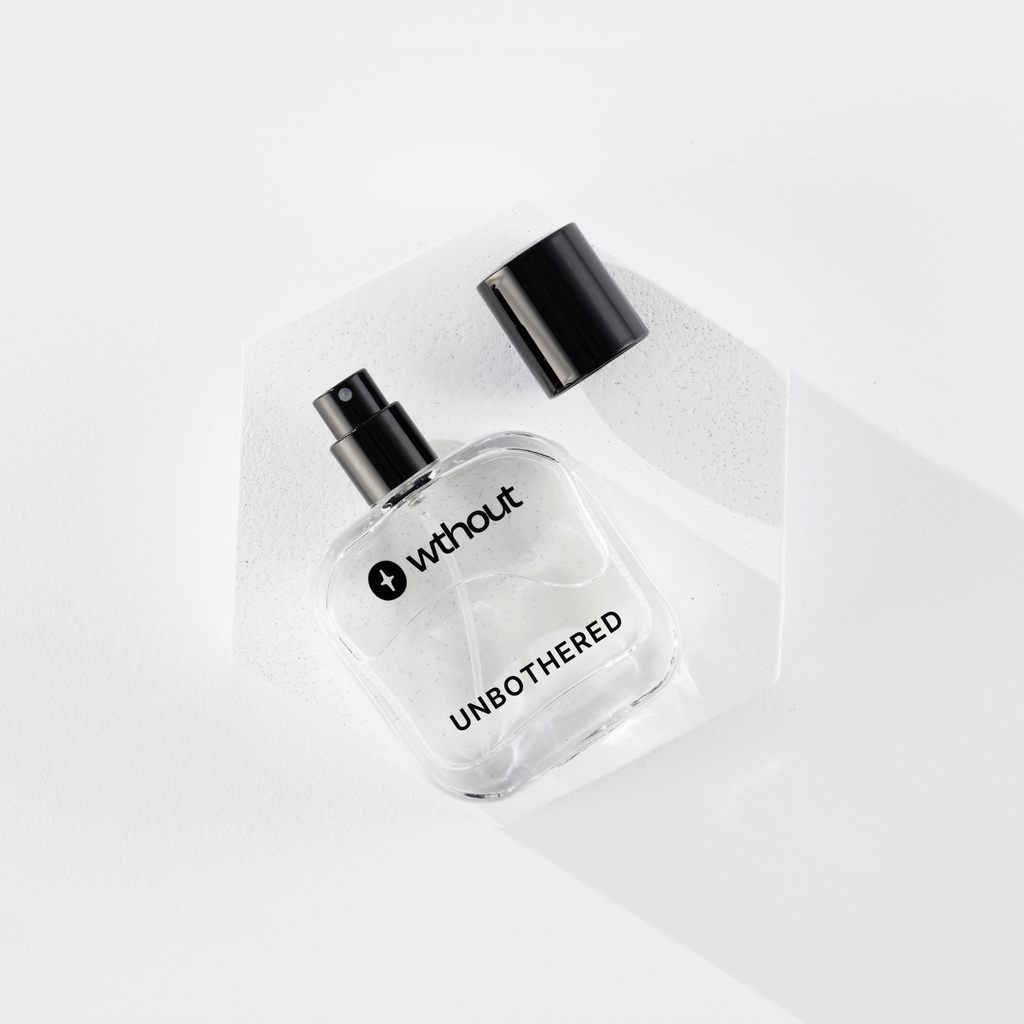 Clear perfume bottle with black cap labeled 'without' on a white background
